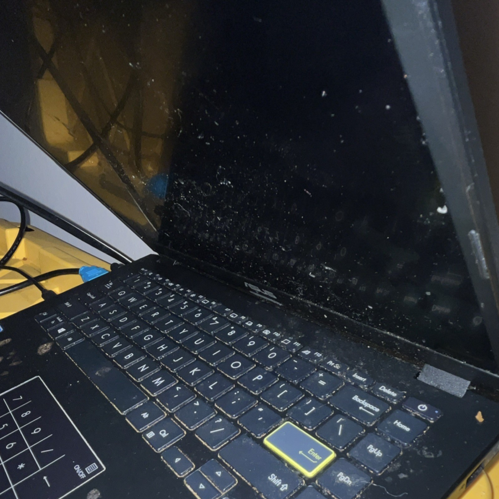 ASUS Black Laptop with Numeric Keypad and Highlighted Enter Key screen is black
